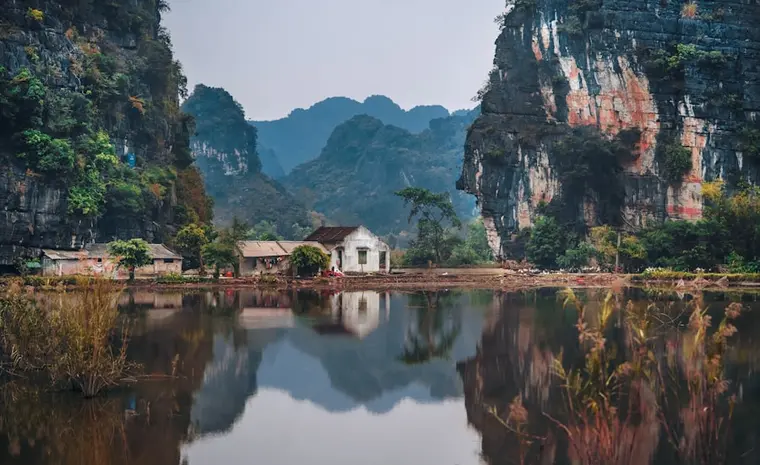 Limestone cliffs reflected in water at Ninh Binh